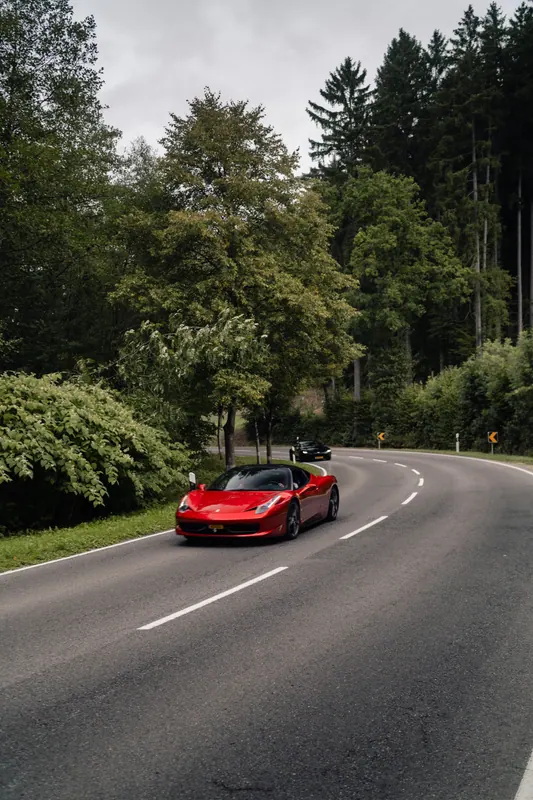 A red Ferrari on a forest road